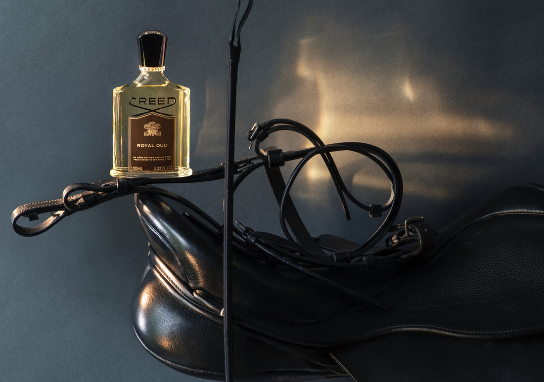 a bottle of Royal Oud atop of some leather riding gear