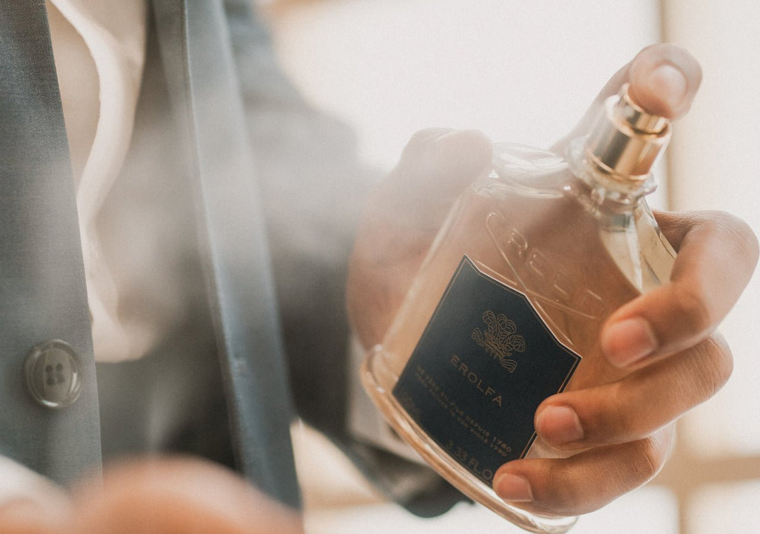 suited man spraying erolfa fragrance on his clothes