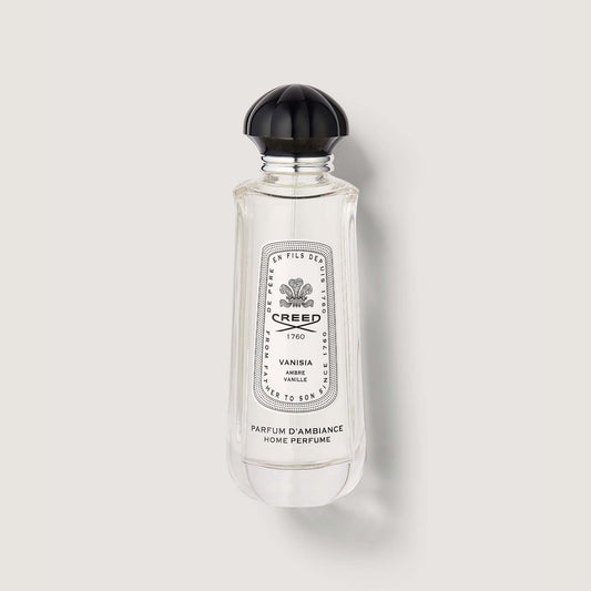 clear bottle of vanisia room spray with black cap and black and white label